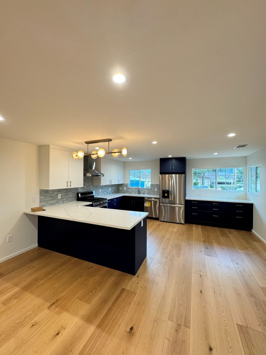 Kitchen remodel with navy island, quartz counters and white oak floors